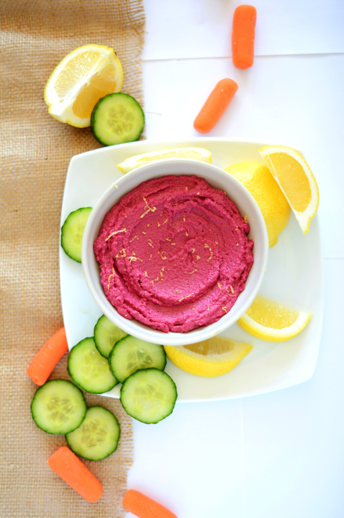 Baby carrots, lemon wedges, sliced cucumber, and a bowl of homemade Roasted Beet Hummus
