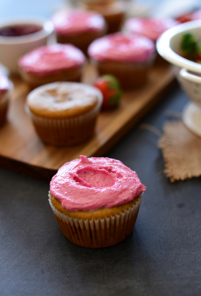 Close up shot of a Strawberry Beet Cupcake with the rest of the batch behind it