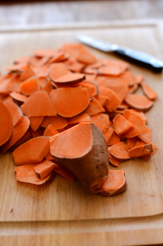Cutting board with sliced sweet potatoes for making a batch of our homemade Sweet Potato Chips