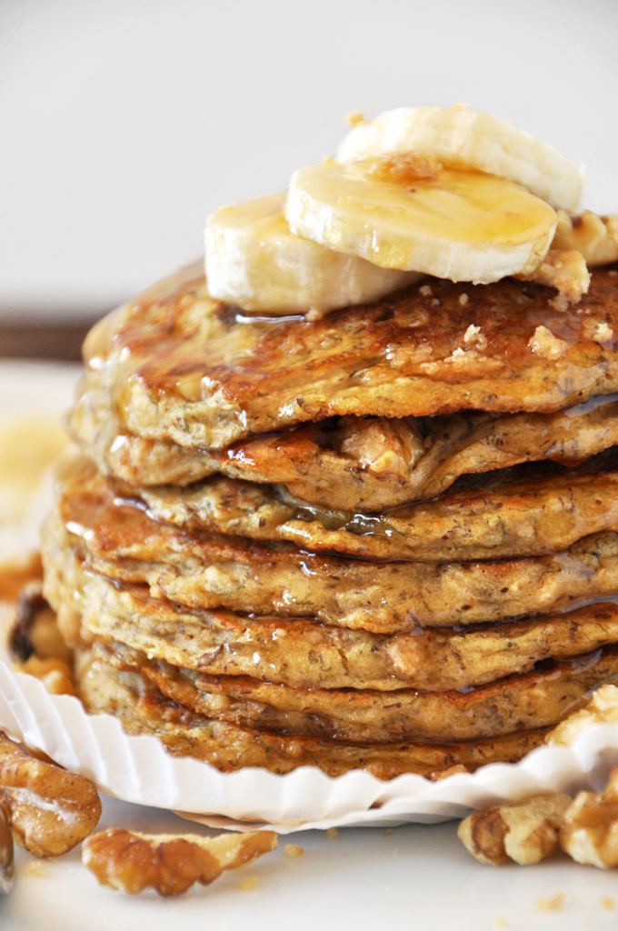 Stack of Vegan Banana Nut Muffin pancakes topped with fresh bananas and streusel