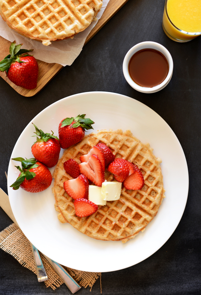 Gluten-Free Oat Waffle topped with fresh strawberries and vegan butter