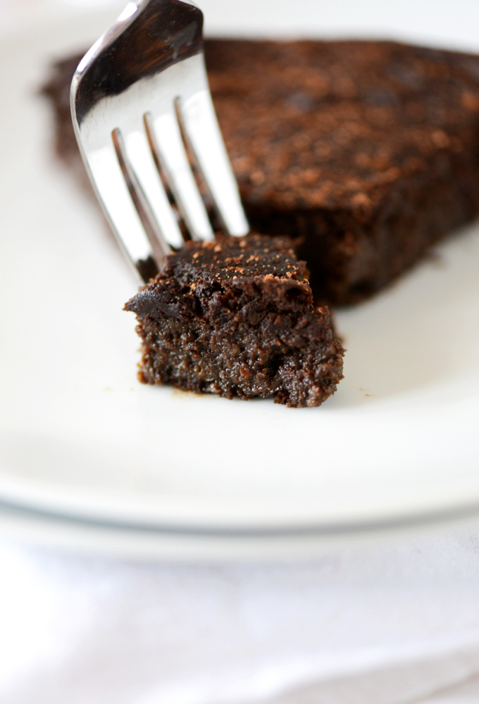 Grabbing a bite of Fudgy Gluten-Free Chocolate Cake from a plate