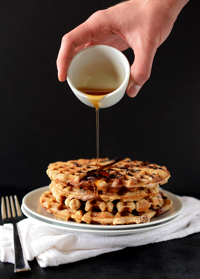 Pouring syrup onto a stack of our GF Vegan Lemon Blueberry Waffle recipe