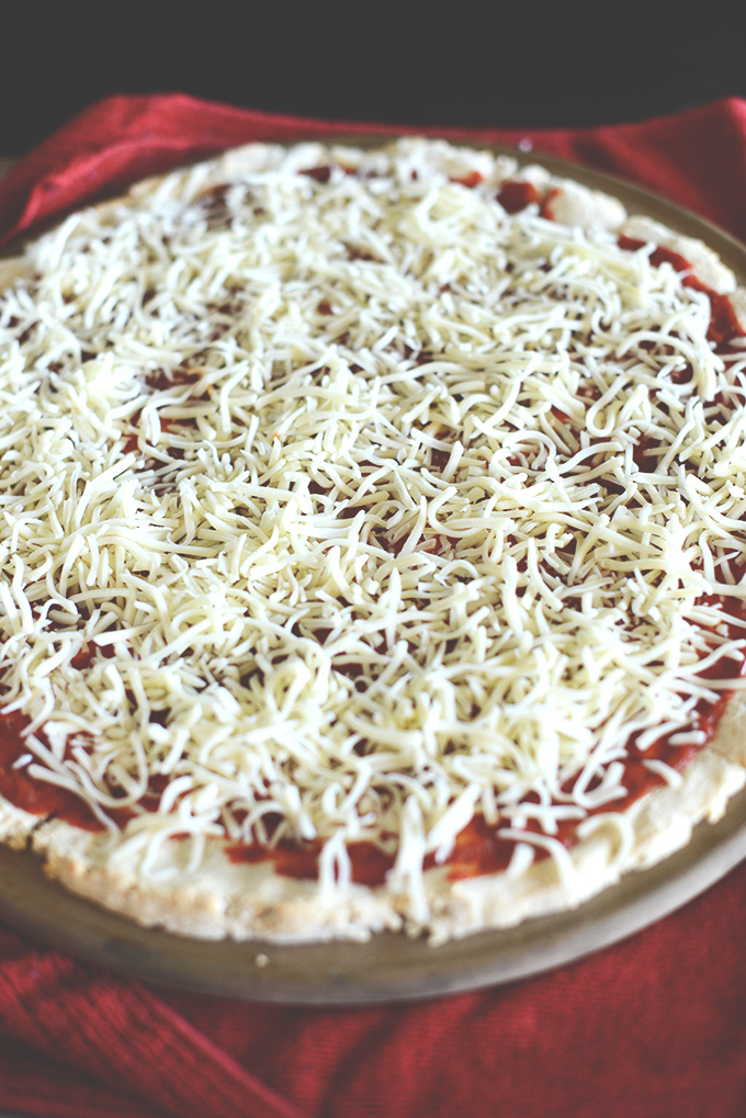 Adding shredded cheese to homemade Gluten-Free Pizza