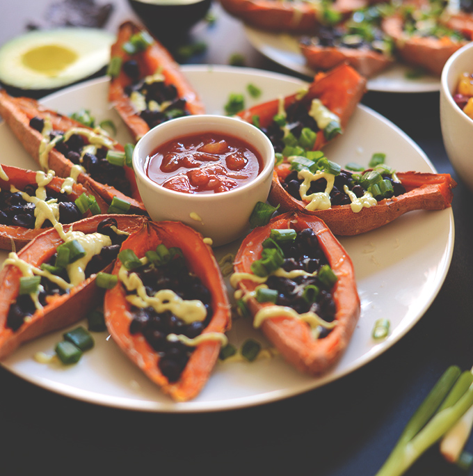 Plate of Loaded Mexican Sweet Potato Boats with a bowl of salsa in the center