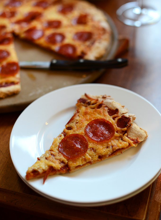 Plate and pizza stone with delicious Gluten-Free Pepperoni Pizza 