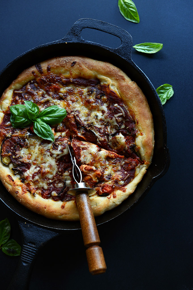 Skillet filled with vegetarian Deep Dish Pizza with fresh basil