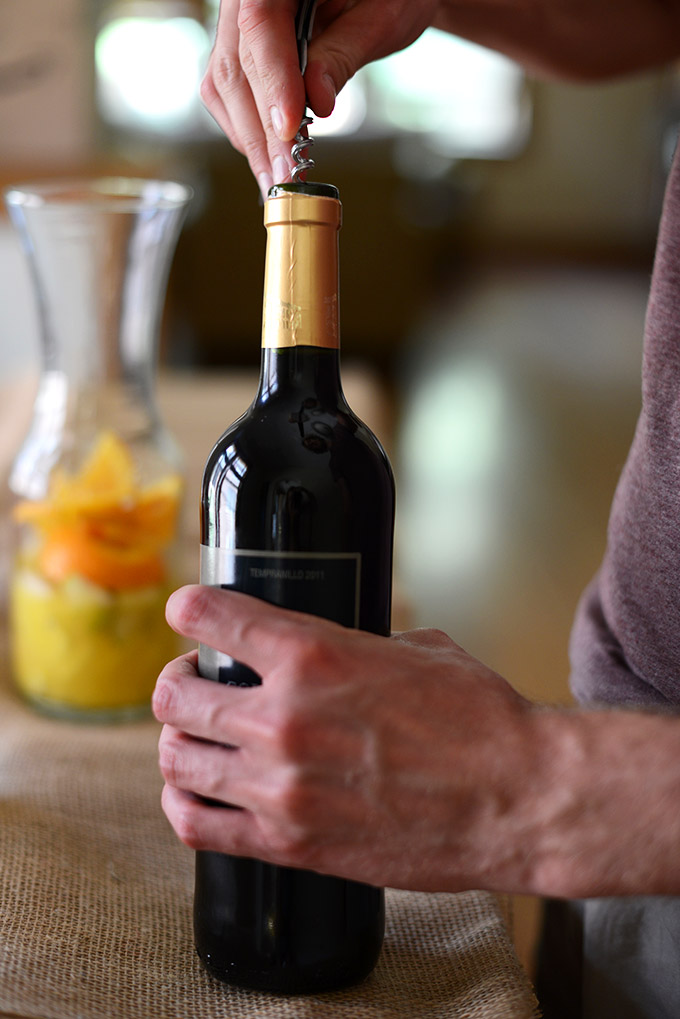 Using a corkscrew to open a bottle of wine for homemade Spanish Sangria