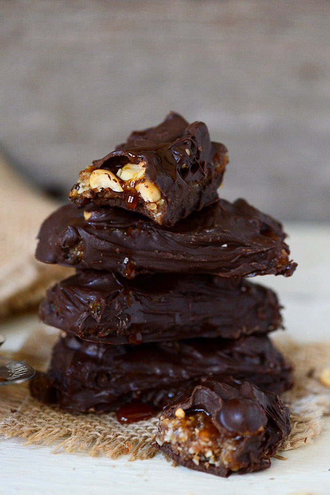 Stack of homemade Vegan Snickers Bars showing the peanuty caramel inside