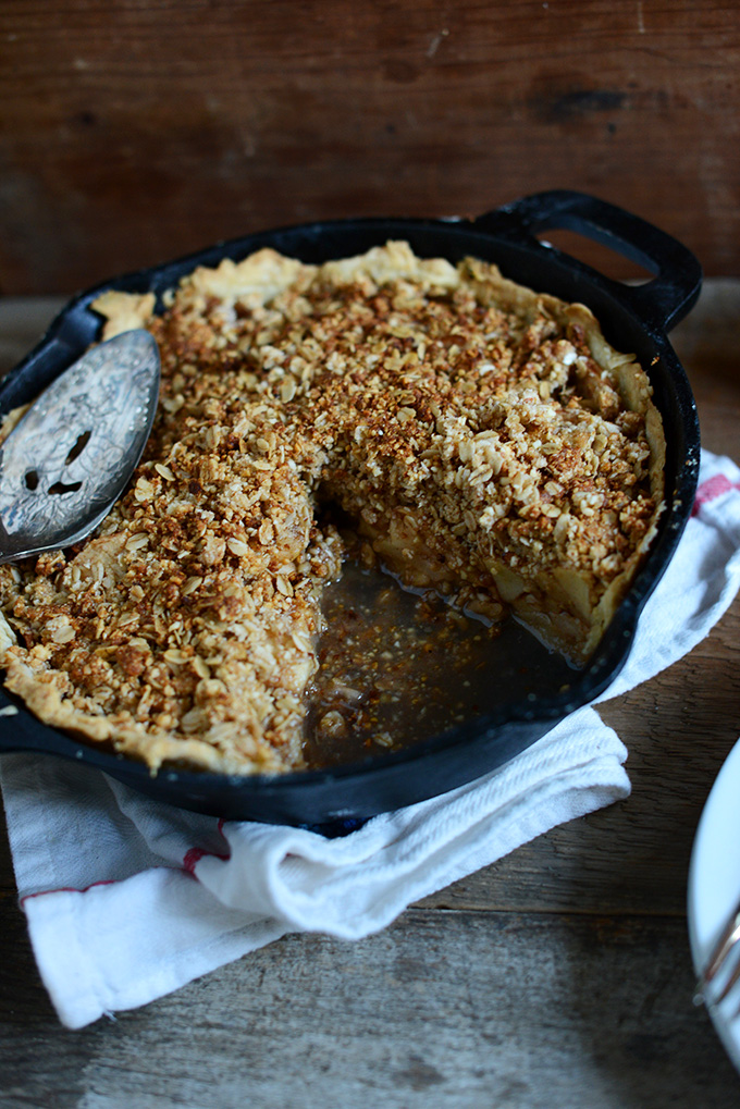 Skillet of vegan Deep Dish Apple Crumble Pie with a slice removed