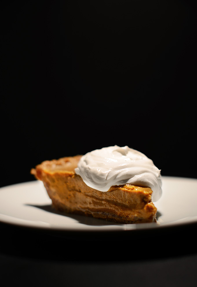 Slice of Vegan No-Bake Pumpkin Pudding Pie with coconut whipped cream