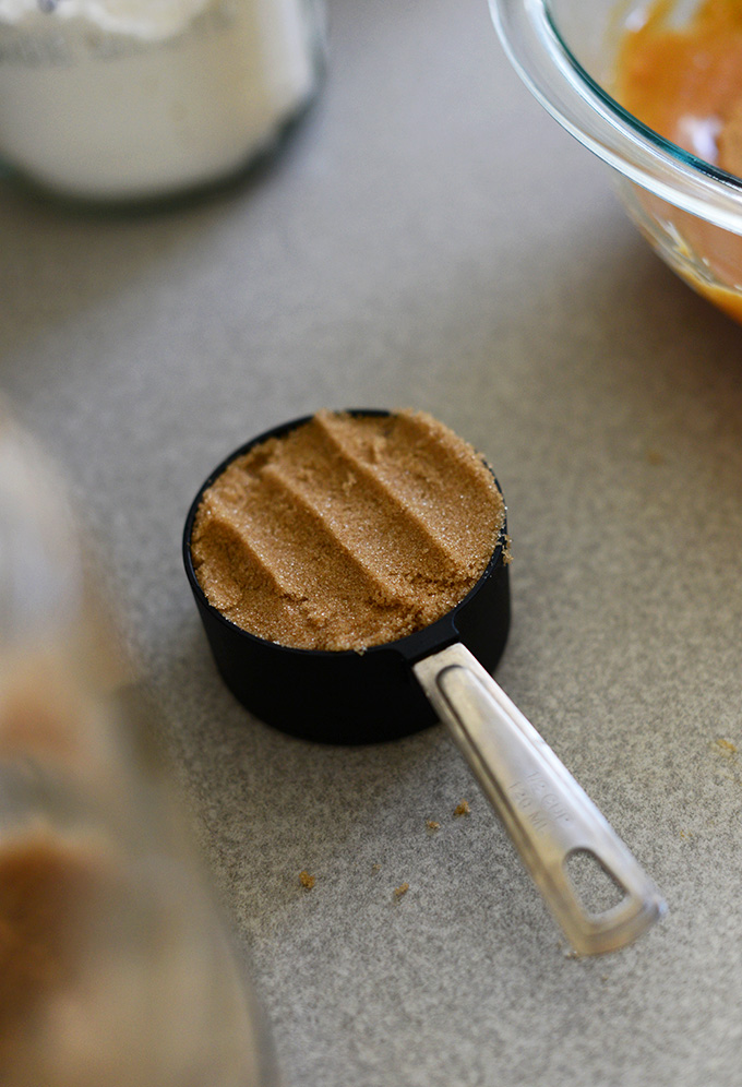 Measuring cup filled with brown sugar for making Vegan Peanut Butter Cookies