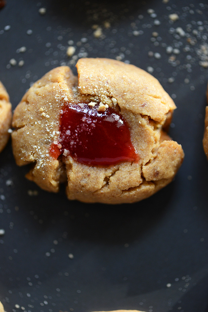 Close up shot of a delicious Peanut Butter & Jelly Thumbprint Cookie for a vegan treat