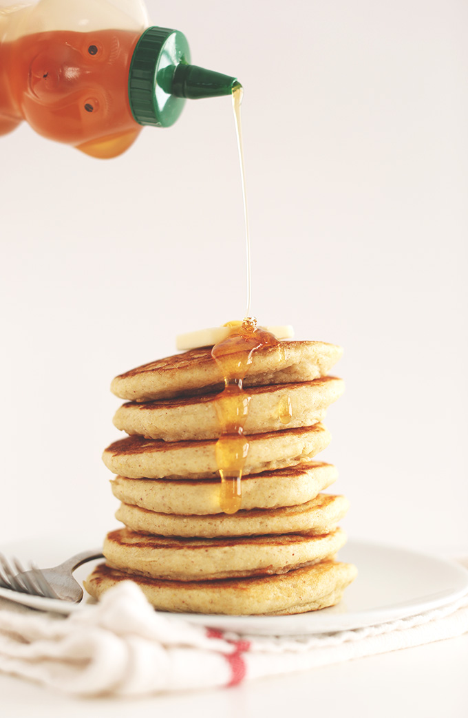 Drizzling honey onto a stack of Fluffy Gluten-Free Pancakes