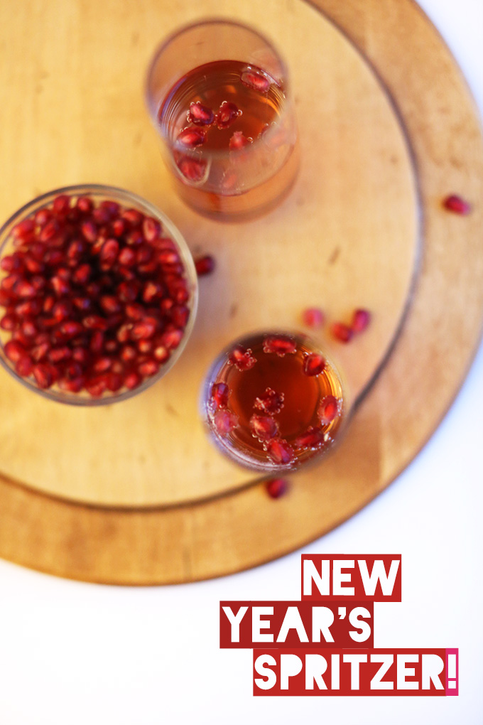 Glasses of St. Germain New Year's Spritzers made with pomegranate seeds