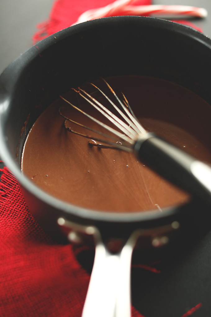 Using a whisk to mix together Vegan Drinking Chocolate ingredients in a saucepan