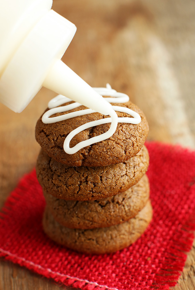 Drizzling icing onto a stack of Vegan Gluten-Free Ginger Snaps