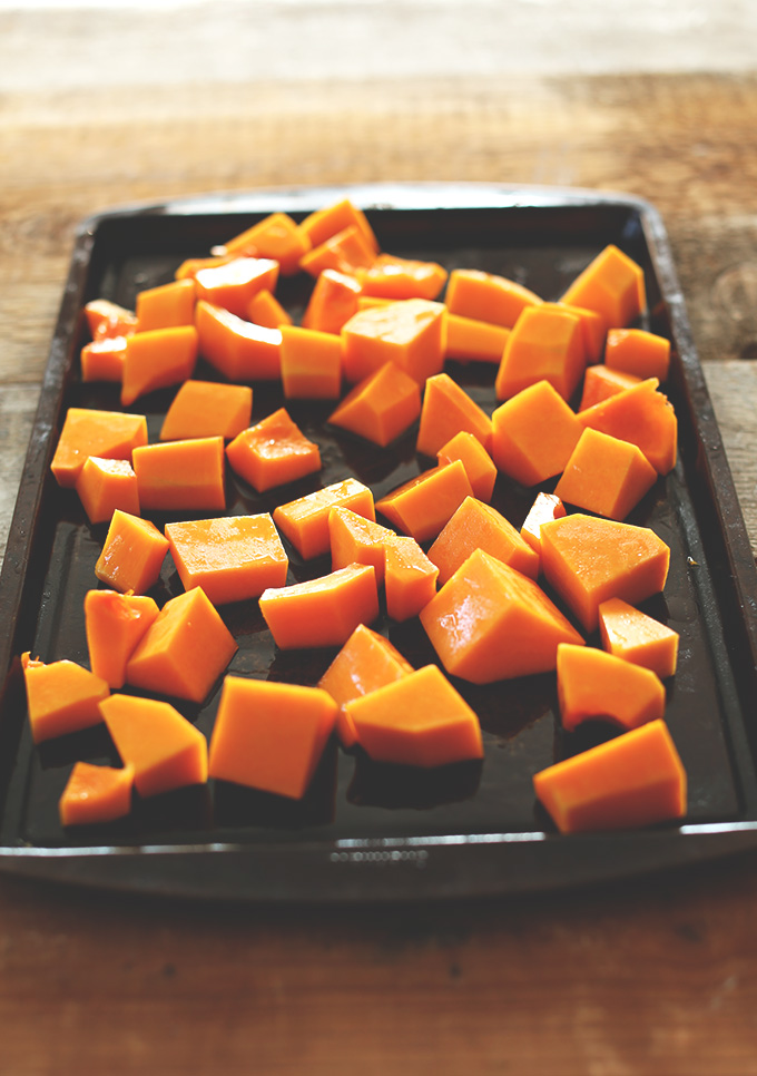 Baking sheet of with chunks of butternut squash ready to be roasted