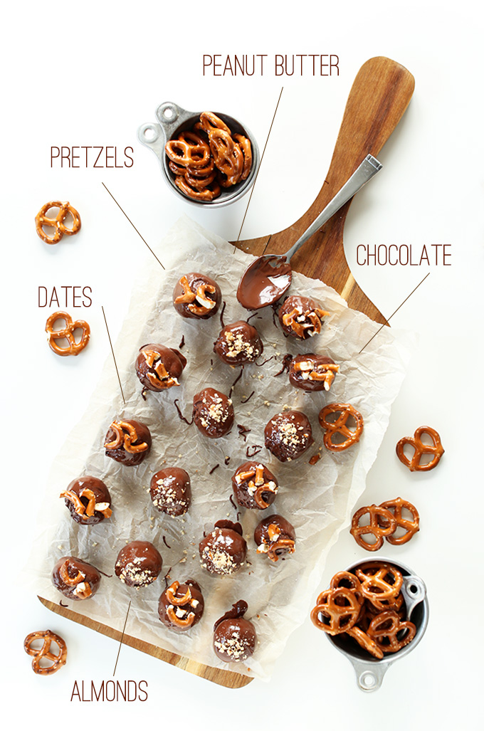 Cutting board filled with Peanut Butter Pretzel Truffles and measuring cups of pretzels