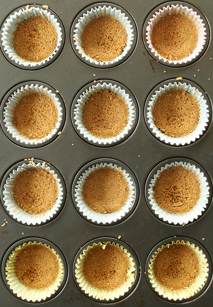 Parchment-lined muffin tins filled with Vegan Graham Cracker Crust
