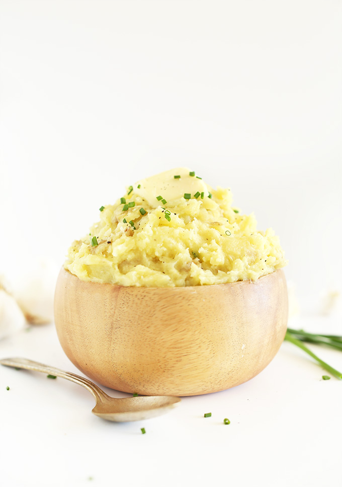 Wood bowl of the Best Damn Vegan Mashed Potatoes topped with chives