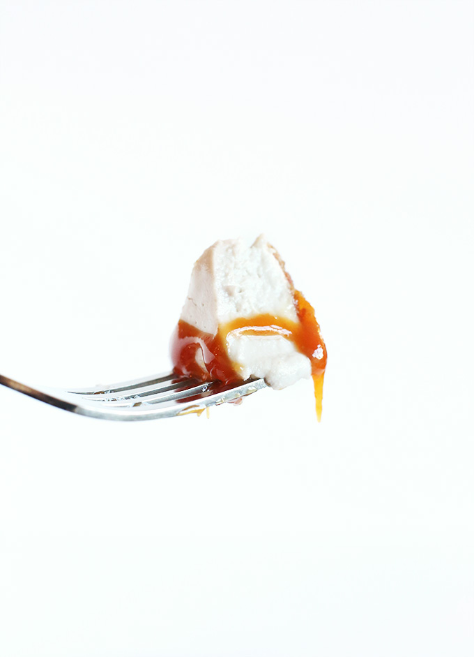 Holding up a bite of Vegan Banana Cream Pie drizzled with caramel sauce