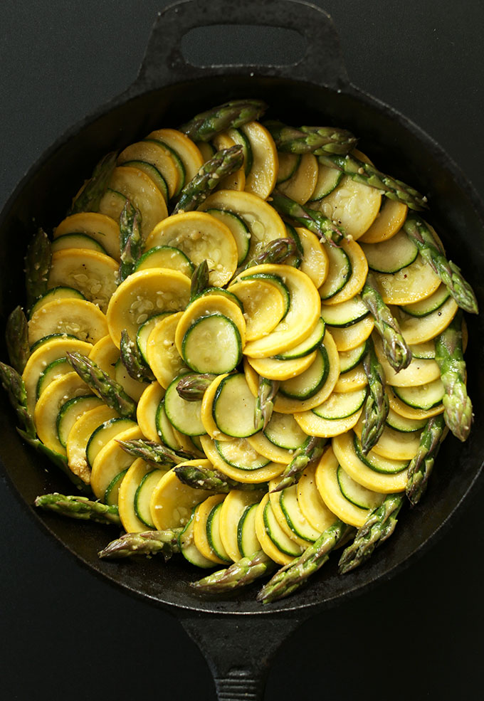 Cast-iron skillet filled with beautiful Vegan Zucchini Asparagus Gratin
