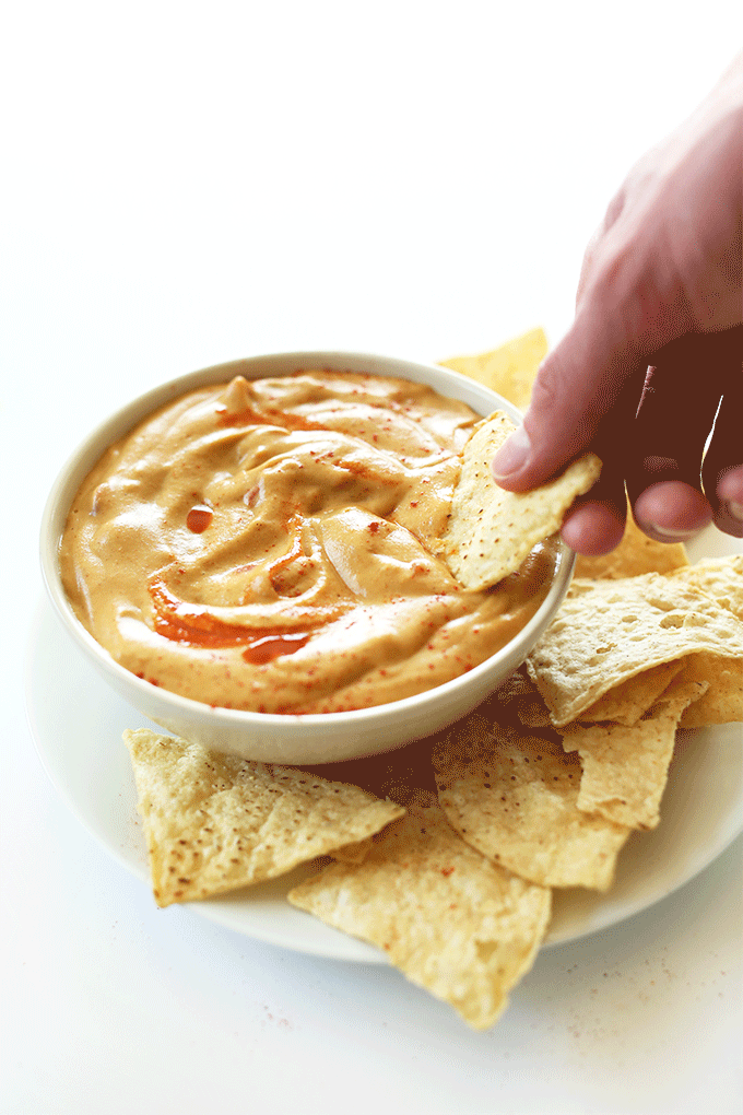 Scooping up cashew-less Vegan Queso Dip on a chip