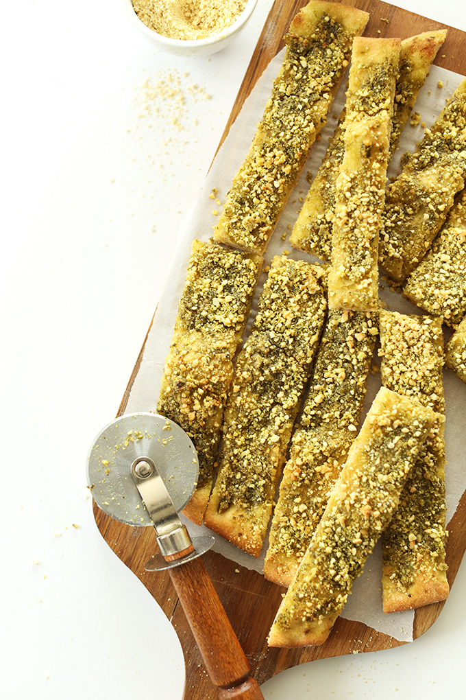 Cutting board with a batch of our Cheesy Pesto Vegan Breadsticks recipe