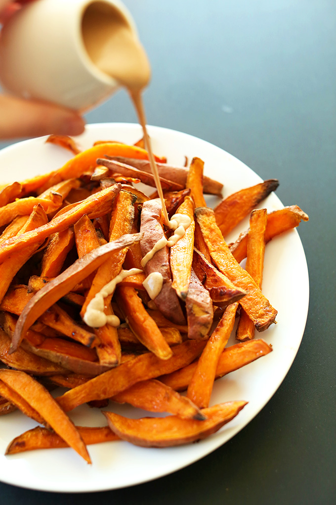 Pouring a peanut butter drizzle over Superfood Sweet Potato Dessert Fries