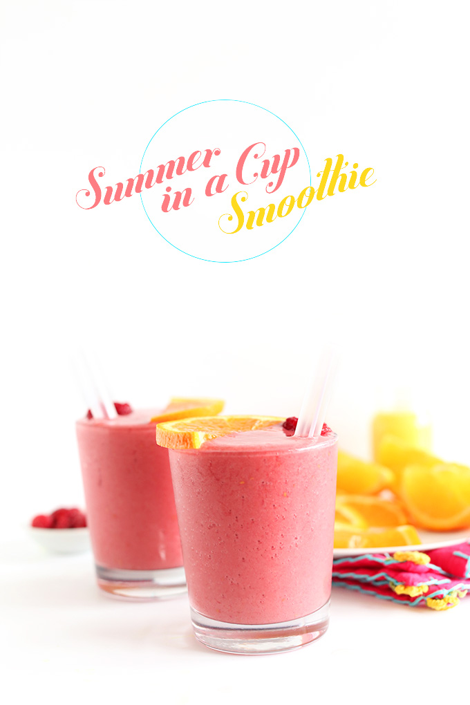 Two glasses of Summer in a Cup Smoothie topped with orange slices and raspberries