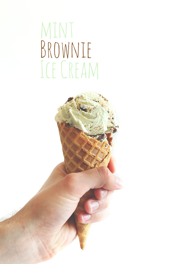 Holding up a waffle cone filled with scoops of Mint Brownie Ice Cream