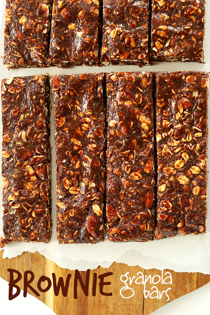 Freshly sliced homemade Brownie Granola Bars on a parchment-lined cutting board