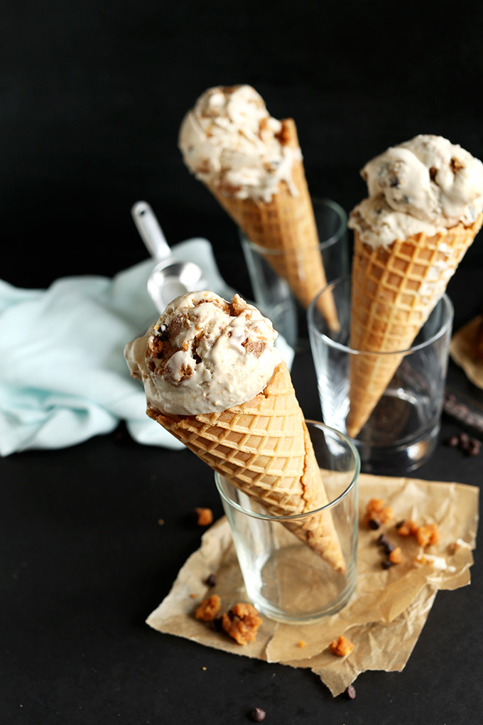 Waffles cones of Vegan Chocolate Chip Cookie Dough Ice Cream held up in glasses