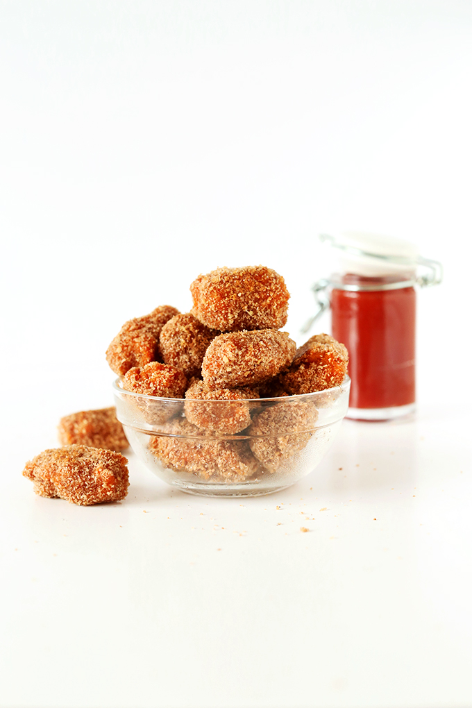 Bowl of Easy Vegan Sweet Potato Tater Tots and a spice jar filled with ketchup