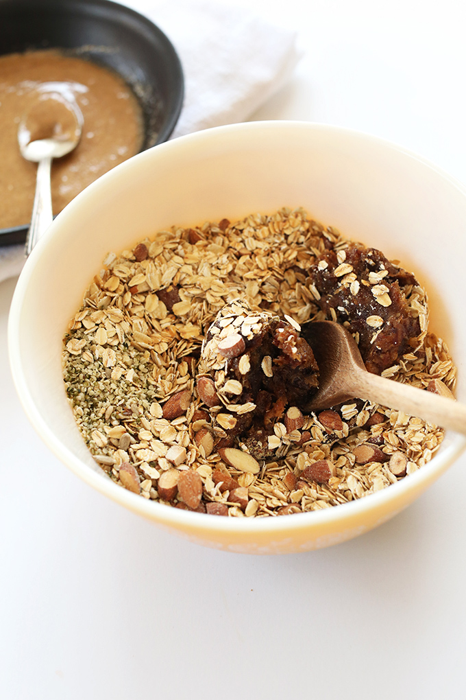 Using a wooden spoon to mix together ingredients for Super Seedy Granola Bars