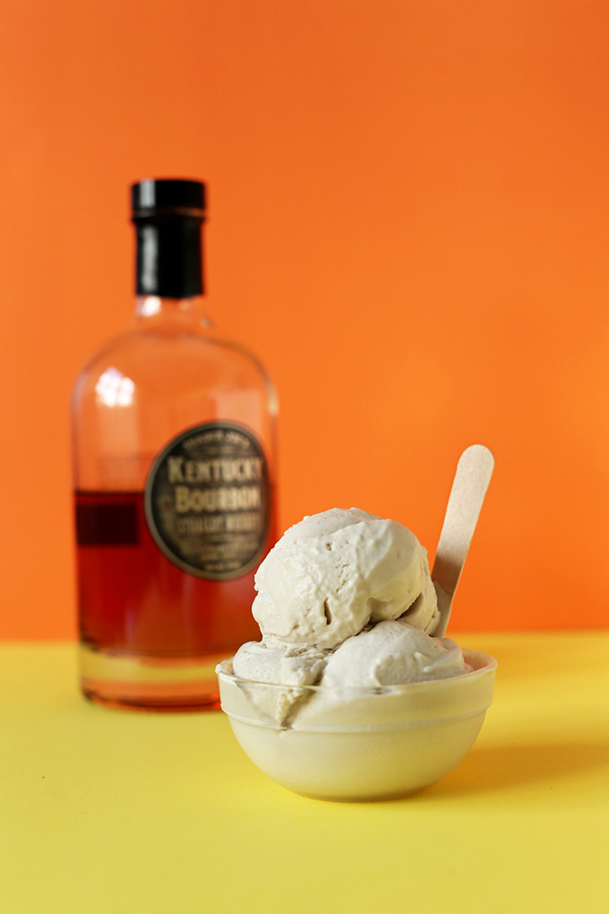 Bowl of Salted Bourbon Caramel Vegan Ice Cream with a bottle of bourbon in the background