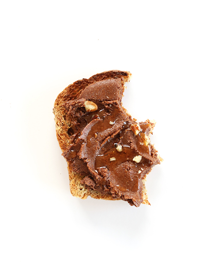 Partially eaten slice of gluten-free toast topped with Vegan Brownie Batter Spread
