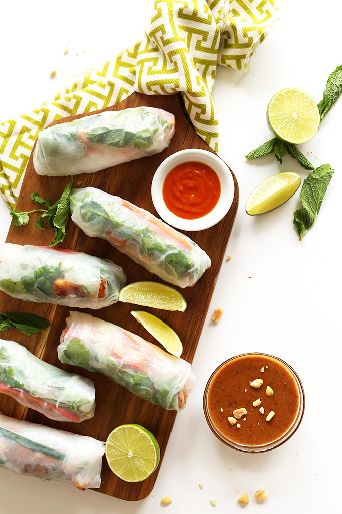 Freshly rolled Vietnamese Vegan Spring Rolls with a bowl of Almond Butter Dipping Sauce