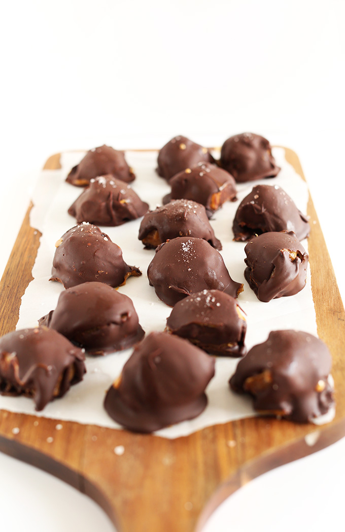A batch of our Vegan Caramel PB Truffles recipe resting on a parchment-lined cutting board
