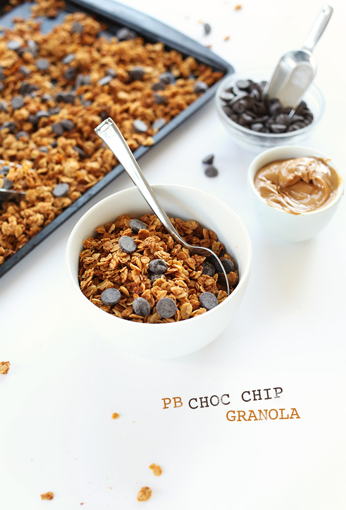 Bowls of peanut butter and chocolate chips beside homemade Peanut Butter Chocolate Chip Granola