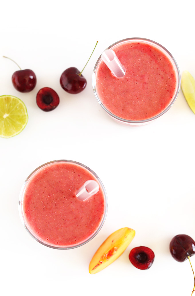 Glasses of our Cherry Limeade Smoothie with fresh cherries and limes