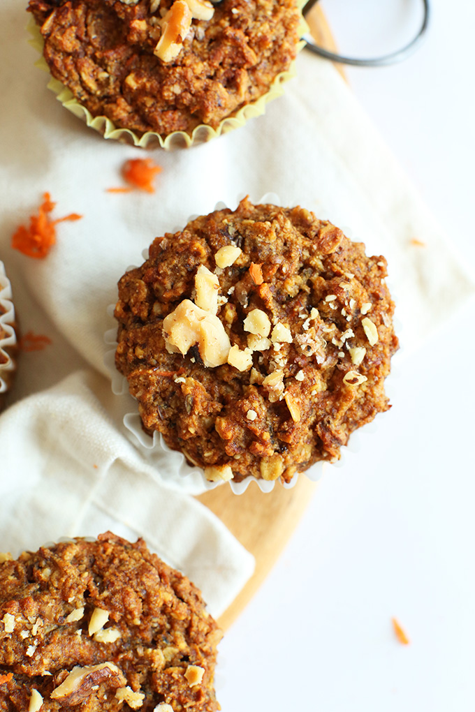 Three gluten-free vegan Carrot Walnut Muffins topped with fresh nuts