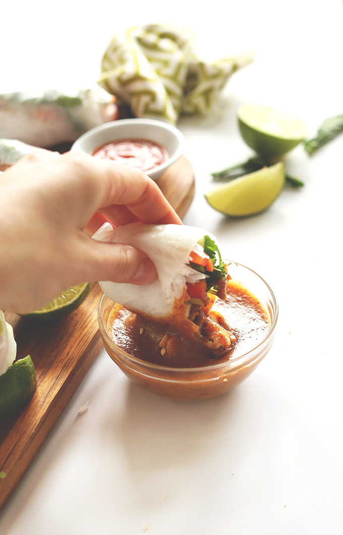 Dipping a healthy Vietnamese Vegan Spring Roll into Almond Butter Dipping Sauce