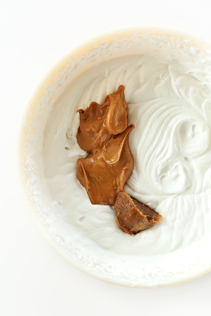 Dollop of peanut butter in a bowl of coconut whipped cream