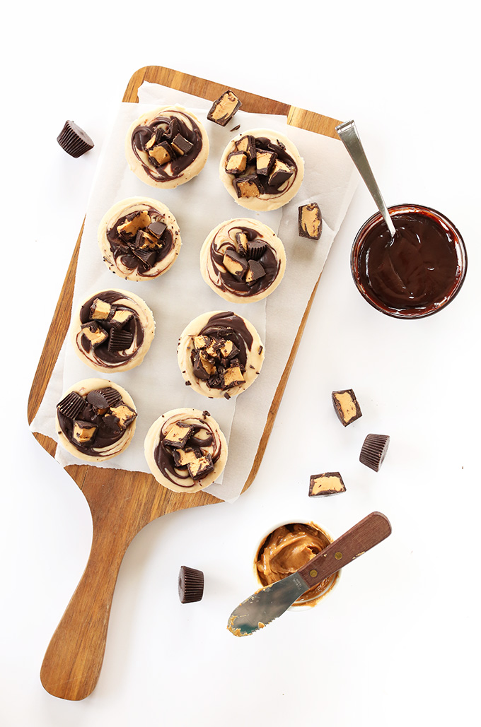 Homemade Vegan Peanut Butter Cup Cheesecakes on a parchment-lined cutting board