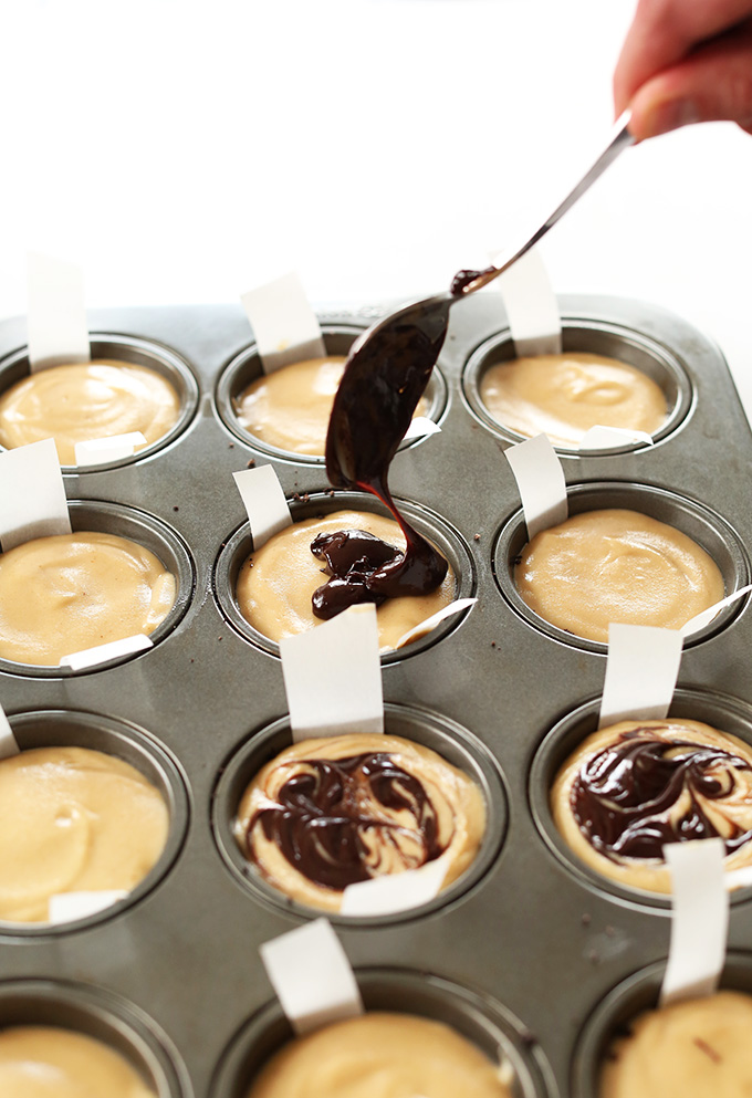Using a spoon to add chocolate drizzle to Vegan Peanut Butter Cup Cheesecakes