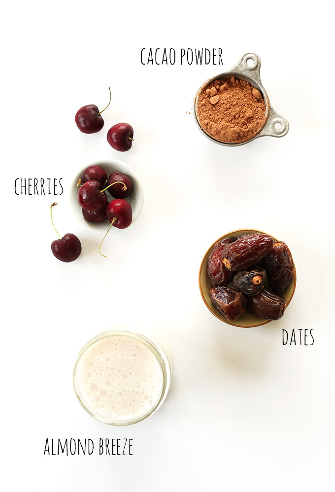 Fresh cherries, cacao powder, dates, and almond milk for making Chocolate Cherry Almond Milk