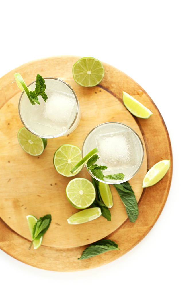 Limes, mint leaves, and two glasses of Coconut Gin and Tonics