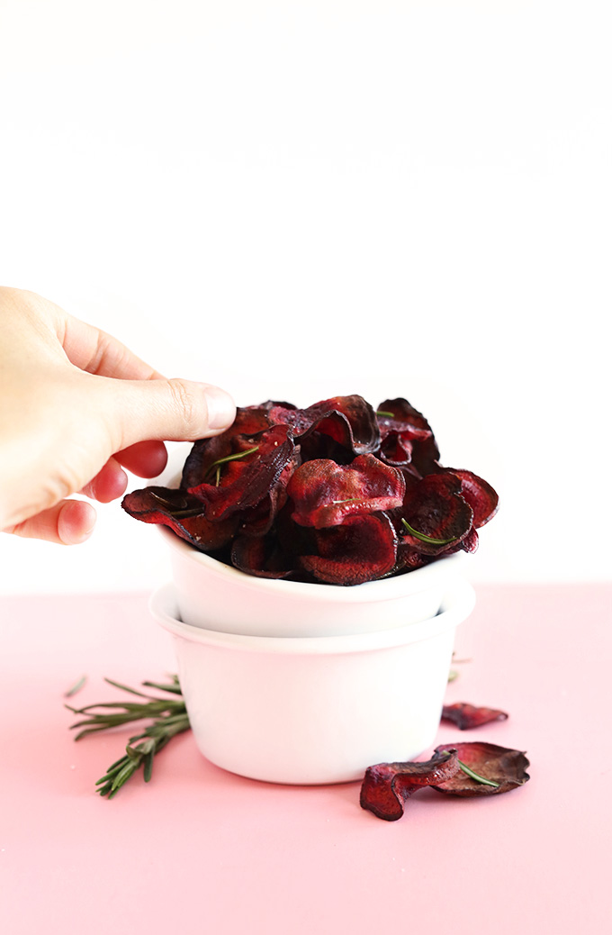 Grabbing a Baked Rosemary Beet Chip for a delicious vegan snack